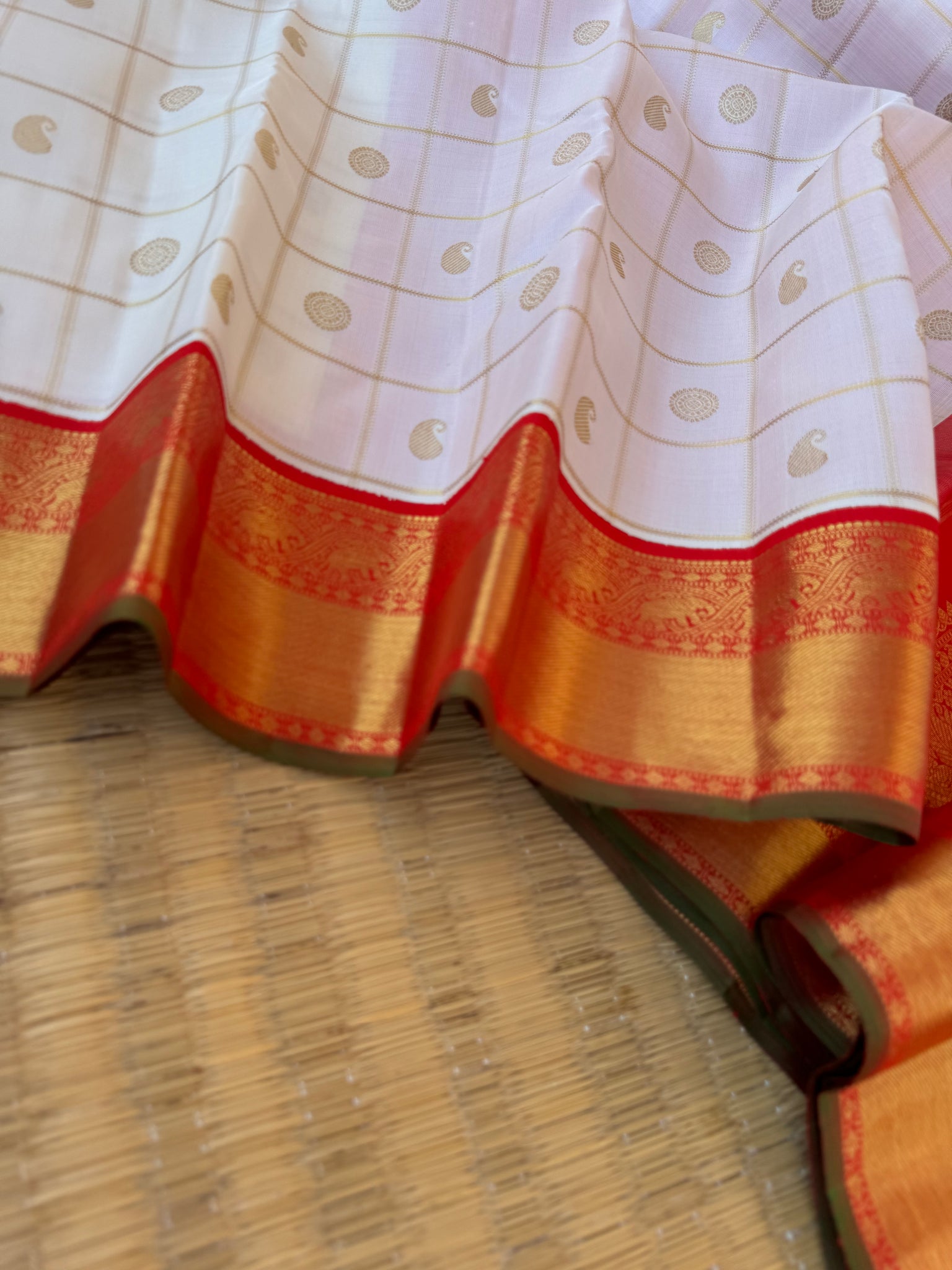 Statement of Kanchivaram - KK2 - one of kind and most fresh from the loom venn pattu ( pure tone of off white ) with red korvai woven solid gold borders with elephant motifs. The paisley and rudurakasham woven kattam buttas add more beauty to the sari !!