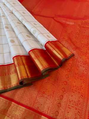 Statement of Kanchivaram - KK2 - one of kind and most fresh from the loom venn pattu ( pure tone of off white ) with red korvai woven solid gold borders with elephant motifs. The paisley and rudurakasham woven kattam buttas add more beauty to the sari !!