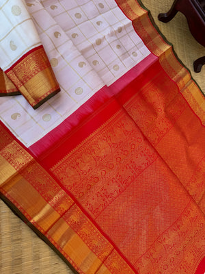 Statement of Kanchivaram - KK2 - one of kind and most fresh from the loom venn pattu ( pure tone of off white ) with red korvai woven solid gold borders with elephant motifs. The paisley and rudurakasham woven kattam buttas add more beauty to the sari !!