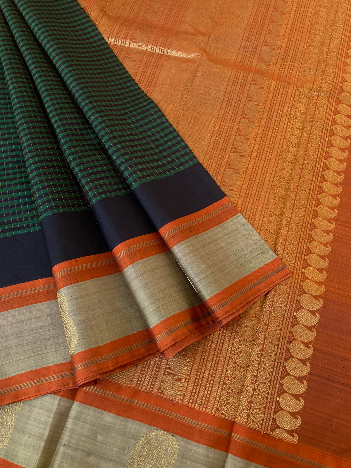 Heriyae - Molten Mettalic Kanchivarams - stunning metallic black and dark green vaari and kattam woven body with rust orange pallu and blouse