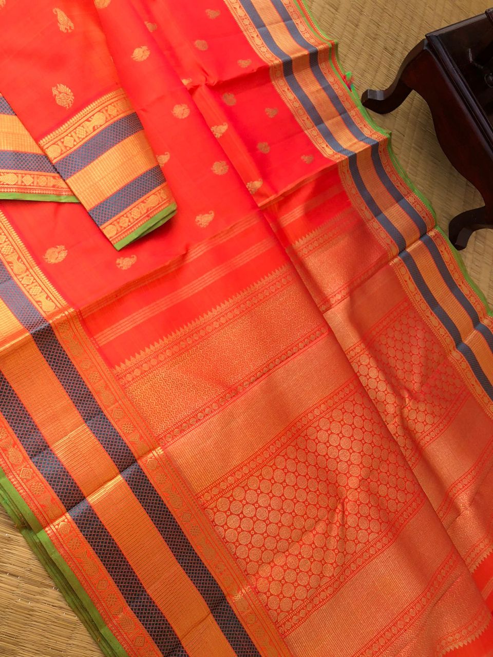 The Golden Treasures Of Kanchivaram - the best red short orange with paisley and pakshi golden buttas over the body with fish pett woven beautiful borders